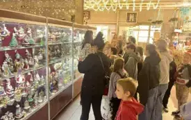 Na zdjęciu dzieci pracujące nad tworzeniem ozd&oacute;b choinkowych lub oglądających gotowe ozdoby