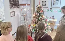 Na zdjęciu dzieci pracujące nad tworzeniem ozd&oacute;b choinkowych lub oglądających gotowe ozdoby