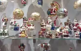 Na zdjęciu dzieci pracujące nad tworzeniem ozd&oacute;b choinkowych lub oglądających gotowe ozdoby