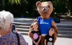 Na zdjęciu dorośli i dzieci bawiący się podczas plenerowej imprezy