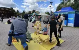 Na zdjęciu dorośli i dzieci bawiący się podczas plenerowej imprezy
