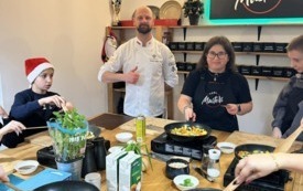 Na zdjęciu osoby, dzieci i dorośli, podczas warsztat&oacute;w kulinarnych