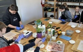 Na zdjęciu osoby, dzieci i dorośli, podczas warsztat&oacute;w kulinarnych