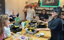 Na zdjęciu osoby, dzieci i dorośli, podczas warsztat&oacute;w kulinarnych