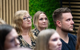 Na zdjęciu grupa dorosłych os&oacute;b przed ekranem projektora