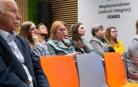 Na zdjęciu grupa dorosłych os&oacute;b przed ekranem projektora