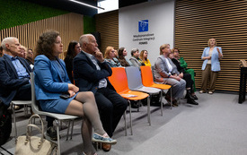 Na zdjęciu grupa dorosłych os&oacute;b przed ekranem projektora