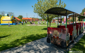 Na zdjęciu dzieci i dorośli bawiący się na pikniku na świeżym powietrzu