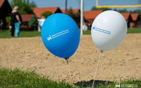 Na zdjęciu dzieci i dorośli bawiący się na pikniku na świeżym powietrzu