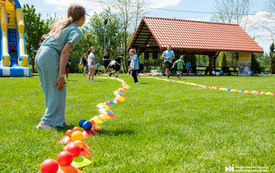 Na zdjęciu dzieci i dorośli bawiący się na pikniku na świeżym powietrzu