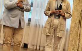 Na zdjęciu osoby w eleganckiej sali konferencyjnej