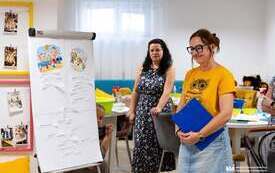 Na zdjęciu dorośli i dzieci tworzący kule zapachowe