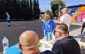 Na zdjęciu osoby na boisku sportowym