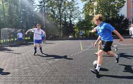 Na zdjęciu osoby na boisku sportowym