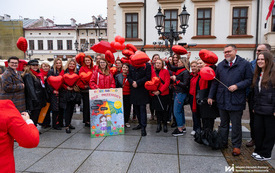 Na zdjęciu tłum os&oacute;b ubranych na czerwono w trakcie wydarzenia plenerowego