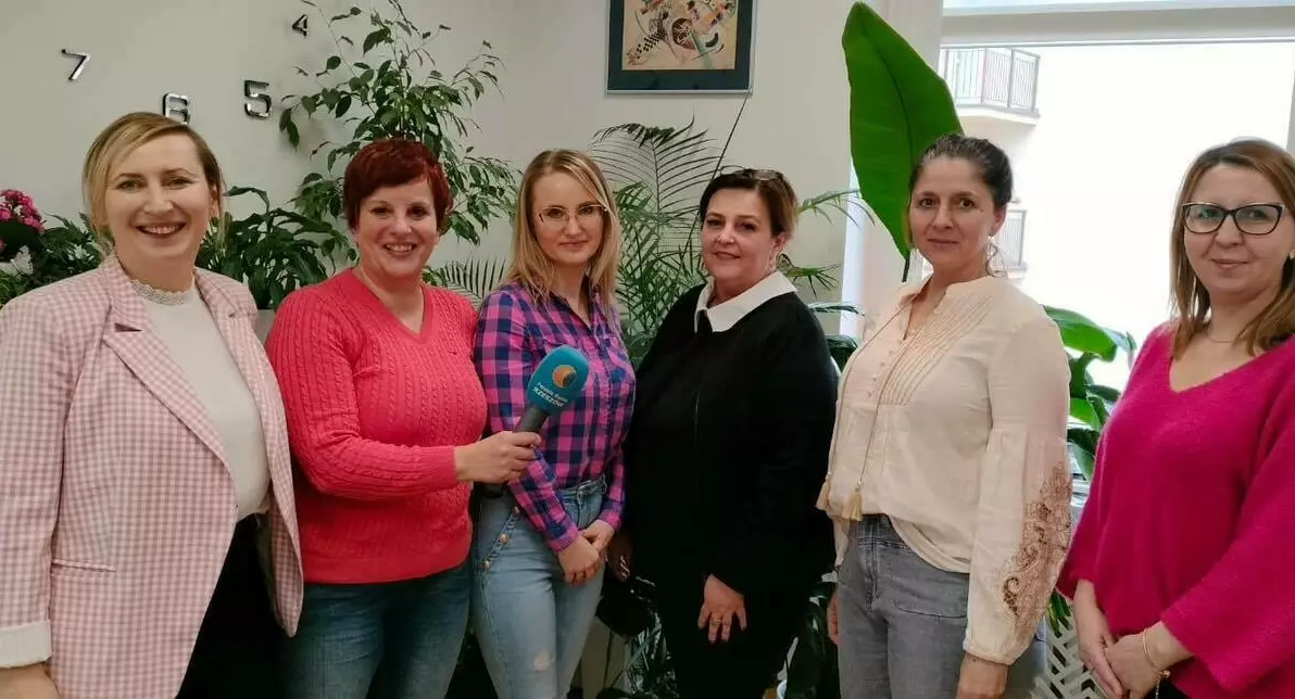 Zdjęcie przedstawia grupę sześciu kobiet w ujęciu od pasa w górę, druga kobieta od prawej trzyma w dłoni niebieski mikrofon z logo Polskiego Radia Rzeszów