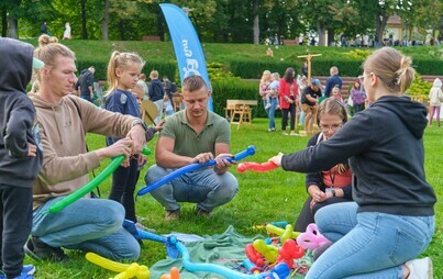 Na zdjęciu grupa osób: dzieci i dorosłych bawiących się na miejskiej imprezie - pikniku